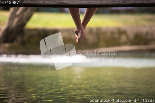 Image of people sitting at wooden bridge