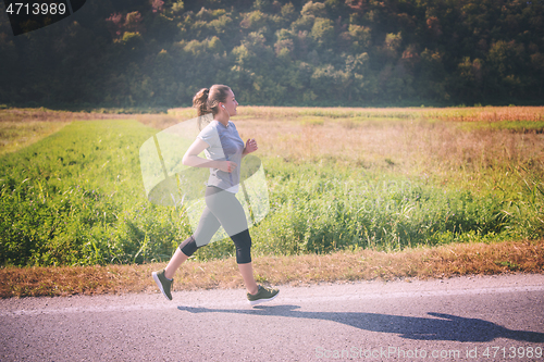 Image of woman jogging along a country road