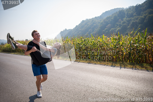 Image of happy couple jogging along a country road