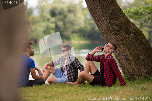 Image of men sitting on the bank of the river