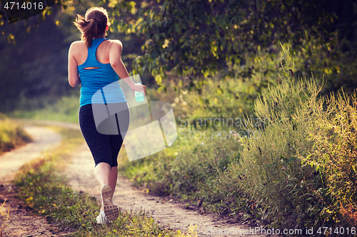 Image of woman jogging along a country road