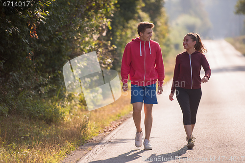 Image of young couple jogging along a country road