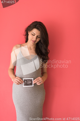 Image of happy pregnant woman showing ultrasound picture