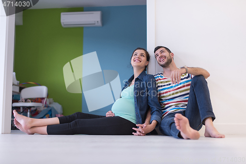Image of pregnant couple sitting on the floor