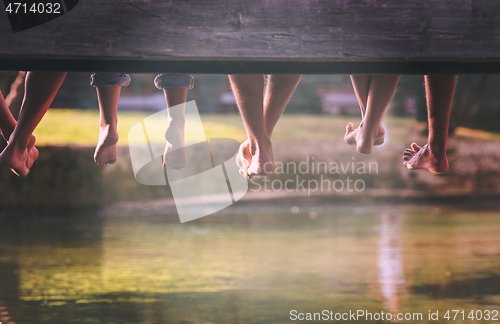 Image of people sitting at wooden bridge