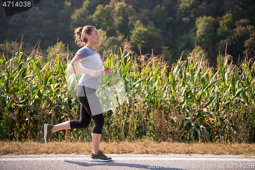 Image of woman jogging along a country road