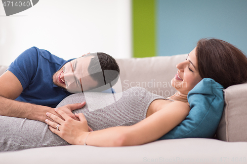 Image of future dad listening the belly of his pregnant wife