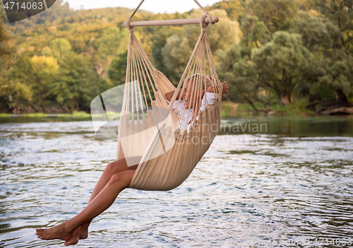 Image of blonde woman resting on hammock