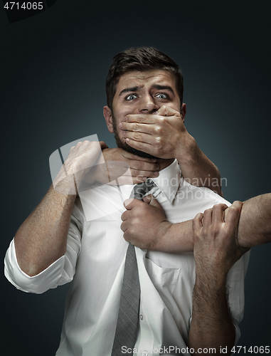 Image of A young man surrounded by hands like his own thoughts