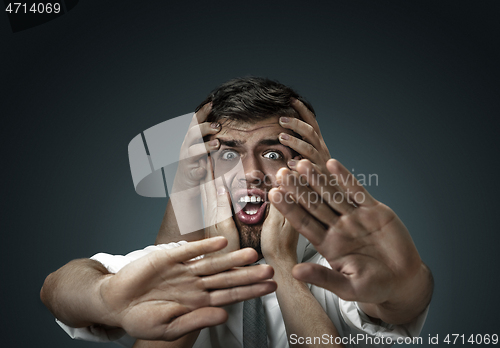 Image of A young man surrounded by hands like his own thoughts