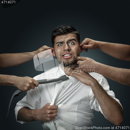 Image of A young man surrounded by hands like his own thoughts