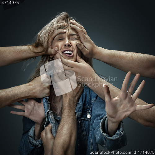 Image of A young woman surrounded by hands like her own thoughts