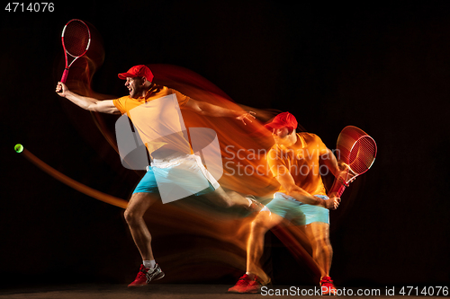 Image of One caucasian man playing tennis on black background