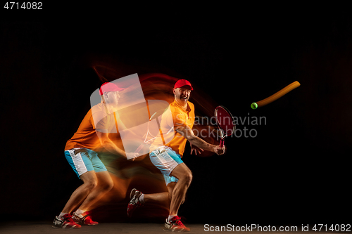 Image of One caucasian man playing tennis on black background