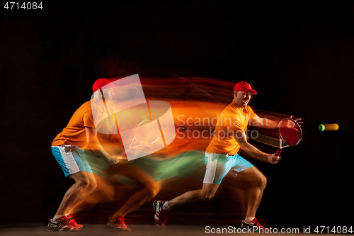 Image of One caucasian man playing tennis on black background