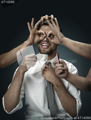 Image of A young man surrounded by hands like his own thoughts