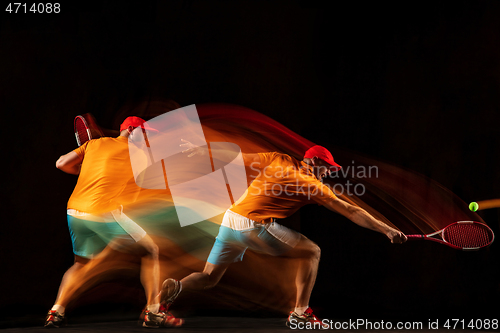 Image of One caucasian man playing tennis on black background