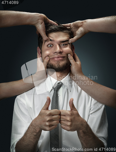 Image of A young man surrounded by hands like his own thoughts