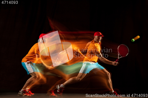 Image of One caucasian man playing tennis on black background