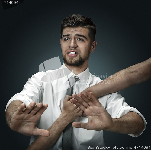 Image of A young man surrounded by hands like his own thoughts