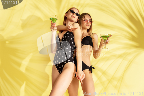 Image of Beautiful girls isolated on yellow studio background