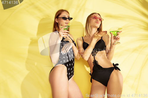 Image of Beautiful girls isolated on yellow studio background