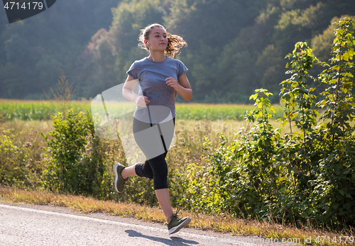 Image of woman jogging along a country road