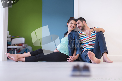 Image of pregnant couple sitting on the floor