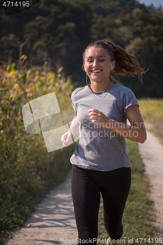 Image of woman jogging along a country road