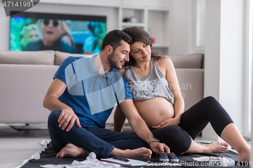 Image of pregnant couple checking a list of things for their unborn baby