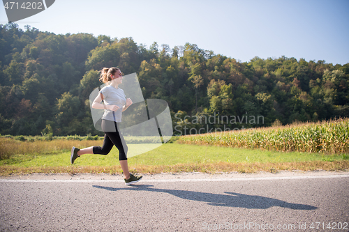 Image of woman jogging along a country road