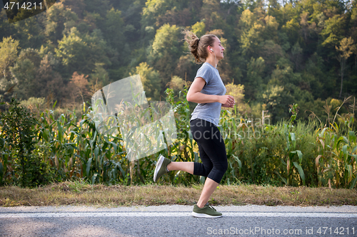 Image of woman jogging along a country road