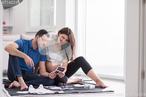 Image of pregnant couple checking a list of things for their unborn baby