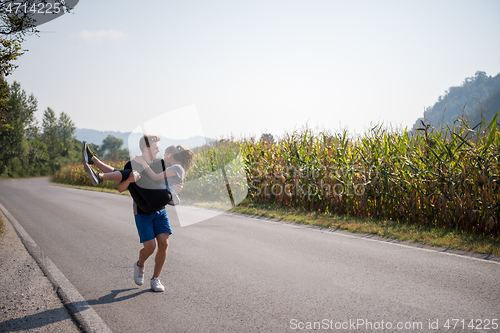 Image of happy couple jogging along a country road