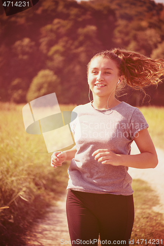 Image of woman jogging along a country road