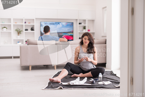 Image of pregnant couple checking a list of things for their unborn baby