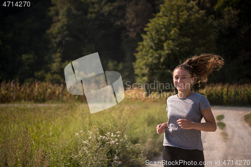 Image of woman jogging along a country road