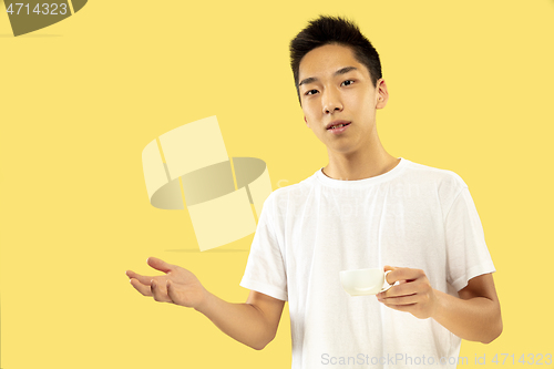 Image of Korean young man\'s half-length portrait on yellow background