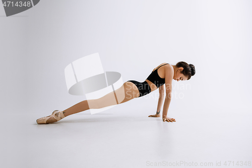 Image of Young female ballet dancer against white studio background