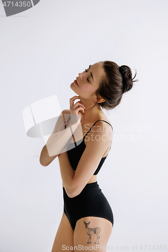 Image of Young female ballet dancer against white studio background