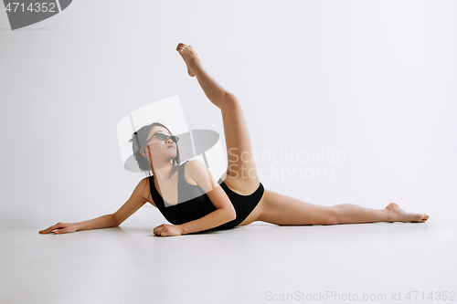 Image of Young female ballet dancer against white studio background