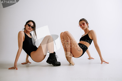 Image of Two young female ballet dancers against white studio background