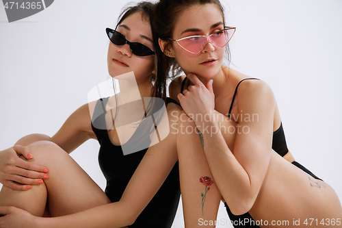 Image of Two young female ballet dancers against white studio background