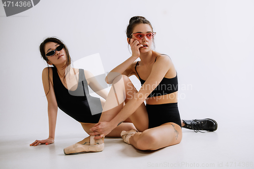 Image of Two young female ballet dancers against white studio background