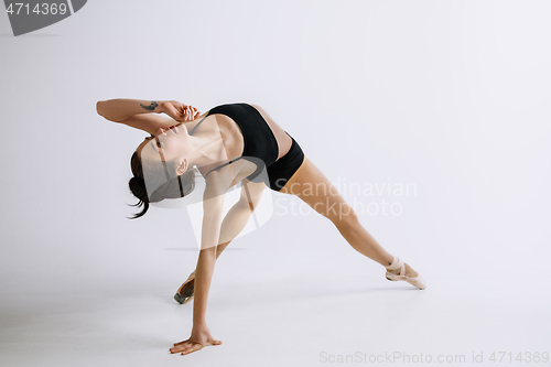 Image of Young female ballet dancer against white studio background