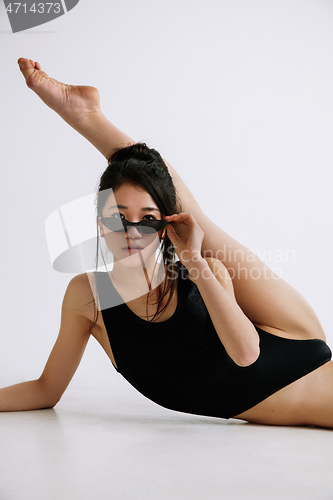 Image of Young female ballet dancer against white studio background