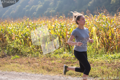 Image of woman jogging along a country road
