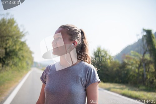 Image of woman jogging along a country road