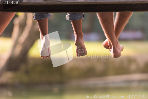 Image of people sitting at wooden bridge