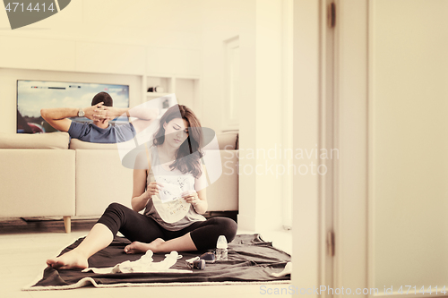 Image of pregnant couple checking a list of things for their unborn baby